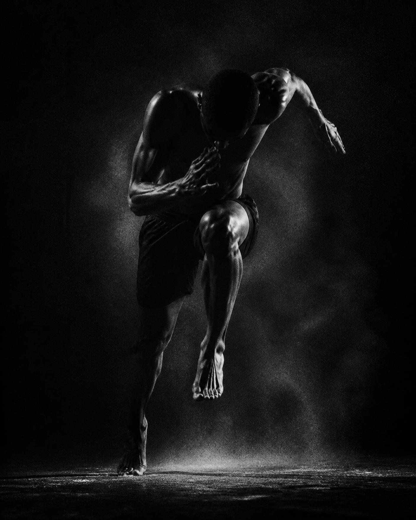 Athlète en mouvement, lumière de studio dramatique en clair-obscur
